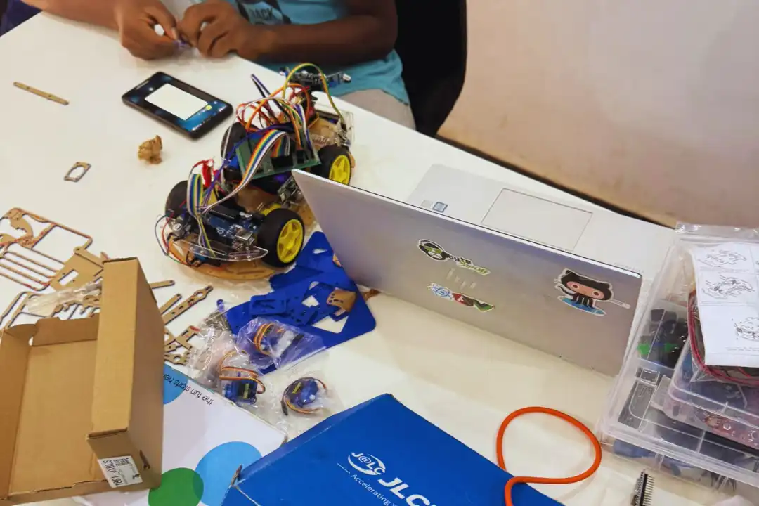 Young child age 7 building colorful LEGO-style robot with sensors and motors